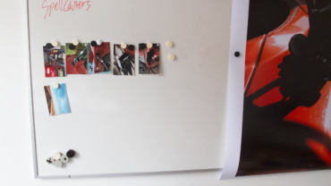 Analogfotos og storformatprint hængt op på whiteboard i værksted